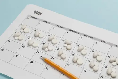 Pill organizer next to a monthly calendar