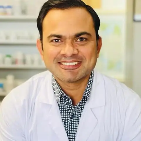 Sathish Cariappa, Rph — Sam — smiling behind the counter at Riverside Pharmacy
